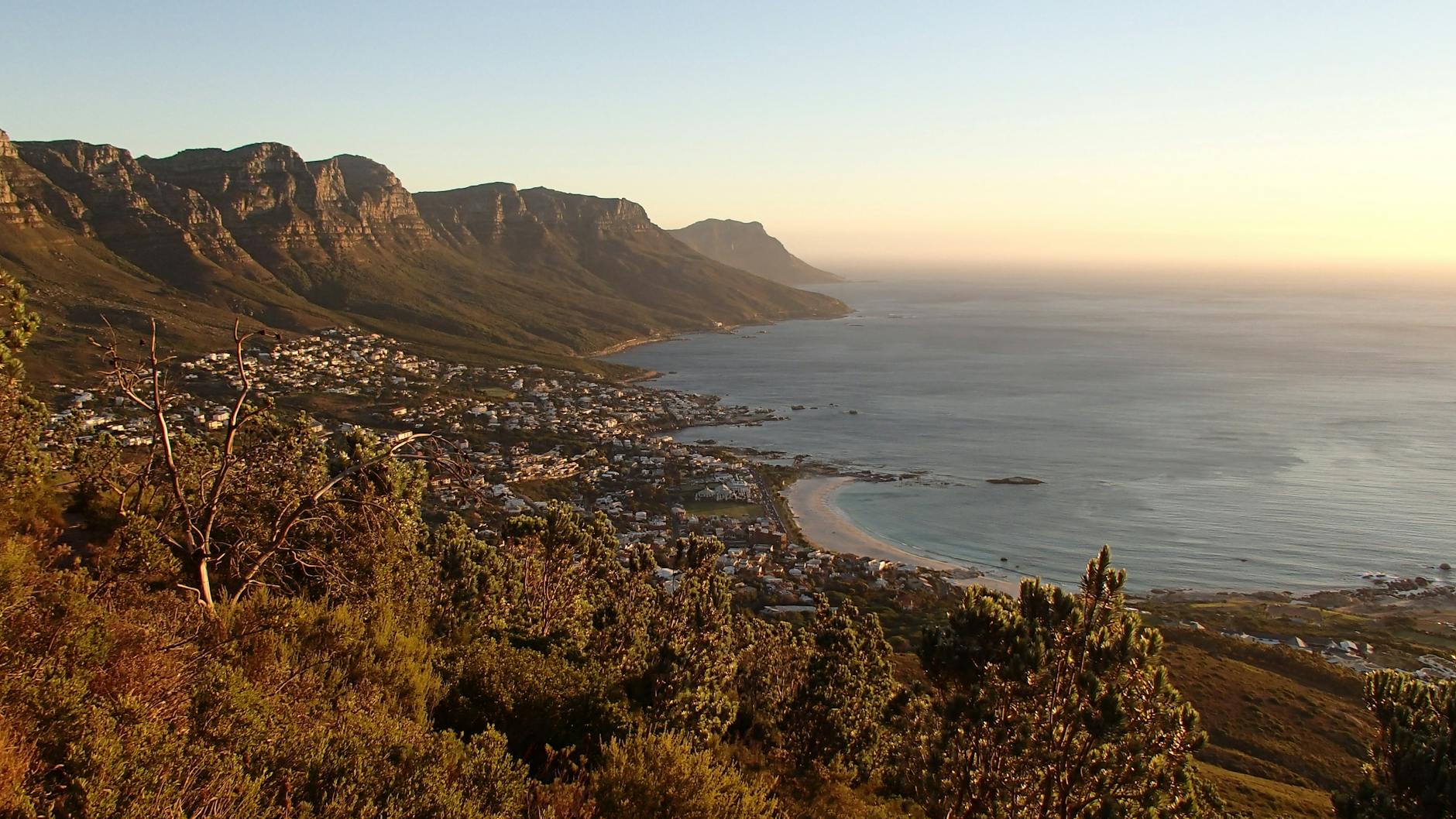 houses near shore surrounded by mountains